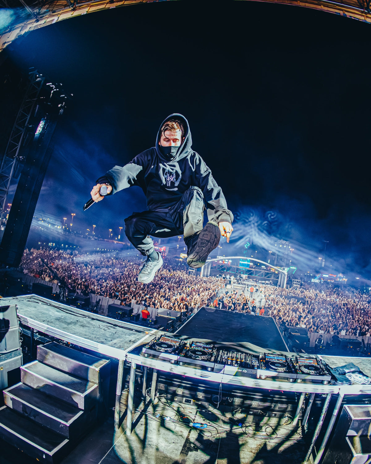 Alan Walker wearing the black Faded Graffiti Hoodie mid jump on stage above a huge festival crowd