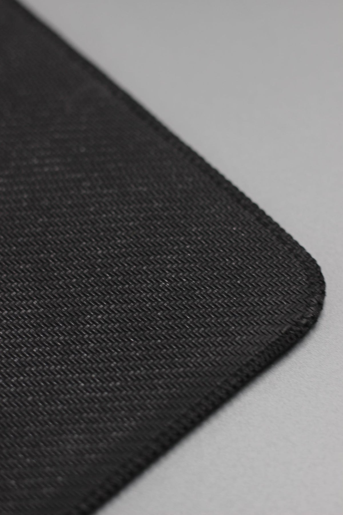 Alan Walker Gaming Mouse Pad edge macro showing the stitched border and woven black cloth surface
