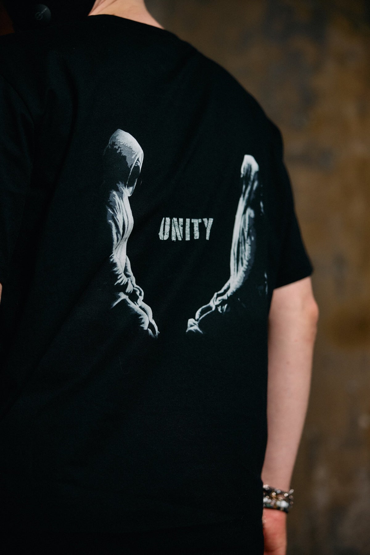 Alan Walker Tired Unity T-Shirt back view on a model, white Unity graphic across the black cotton tee