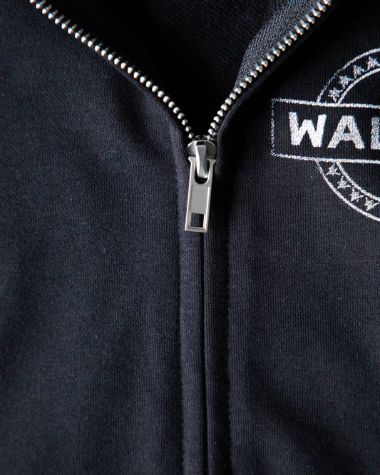 Alan Walker Kids Zip Hoodie detail shot of the metal zipper and woven Walker crest badge on black fleece