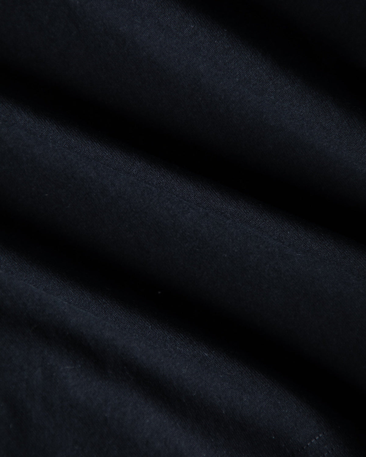 Alan Walker World of Walker Skyline T-shirt fabric close-up showing the heavyweight black cotton and stitching