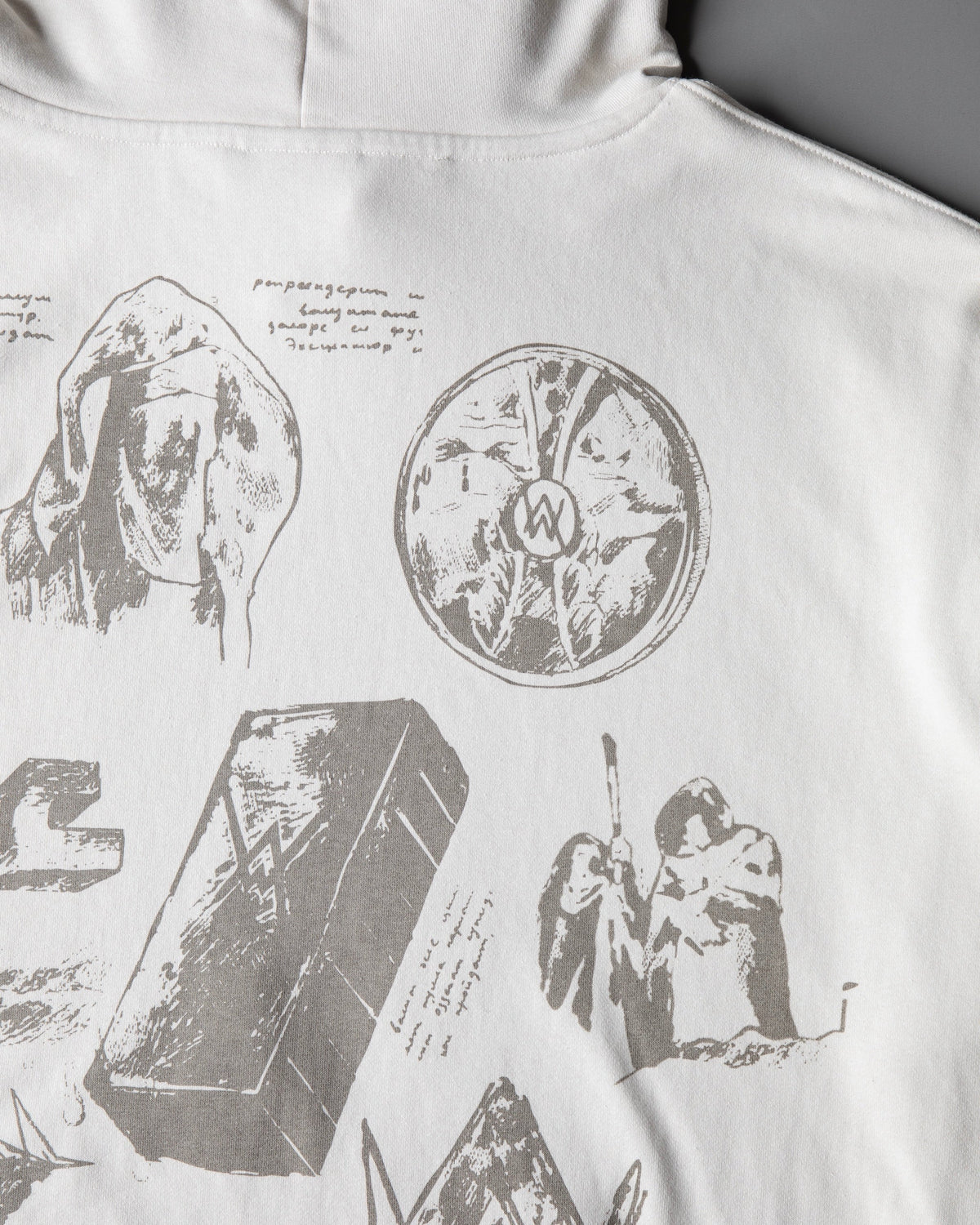 Alan Walker Encyclopedia Hoodie back print detail on off-white cotton, etched relic sketches and a Walker crest medallion