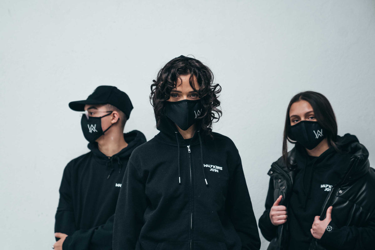 Alan Walker Core Logo Zip Hoodie worn by three masked fans in black, front zip and chest print in view