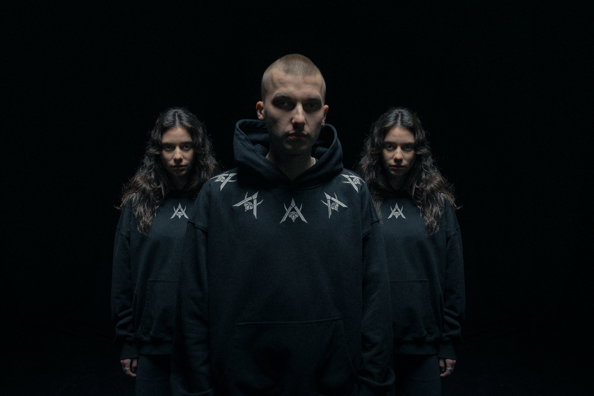 Alan Walker Watch The Drone Hoodie worn by three models in dark lighting, silver chest glyphs on black hoodies