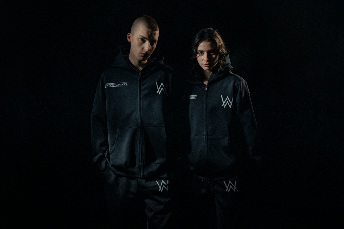 Alan Walker World of Walker Skyline Bundle worn by two models in the dark, matching black zip hoodies and joggers