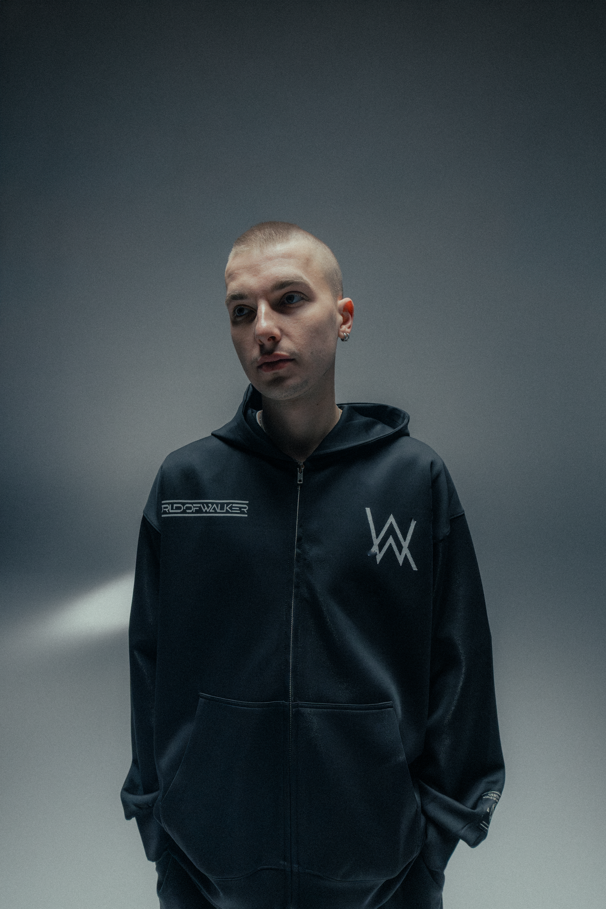Alan Walker World of Walker Skyline Zip Hoodie worn by a model, black zip-up with white AW logo on the chest