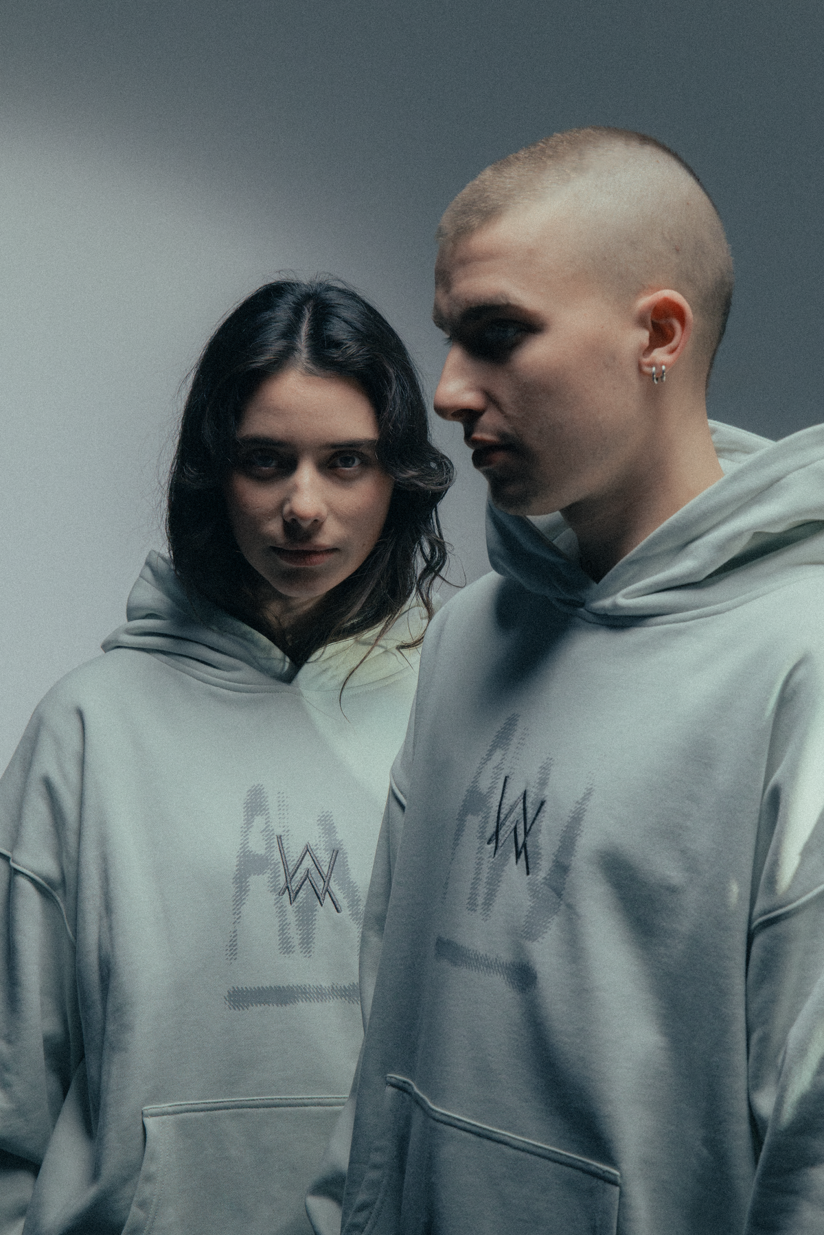 Alan Walker Faded Graffiti Hoodie off white worn by two models in studio, matching painted AW chest logos