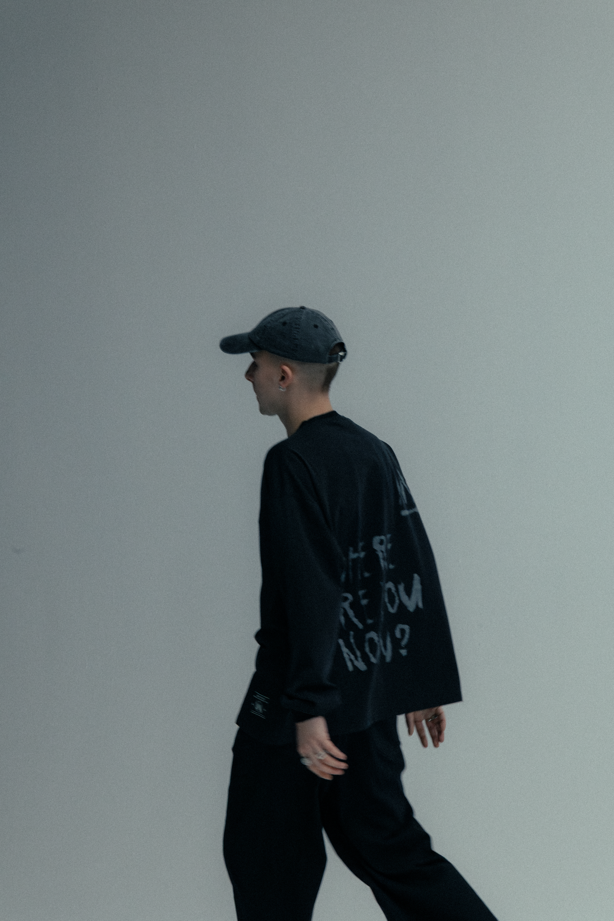 Alan Walker Faded Graffiti Longsleeve worn with a cap, side profile walking shot in black Walker fan apparel