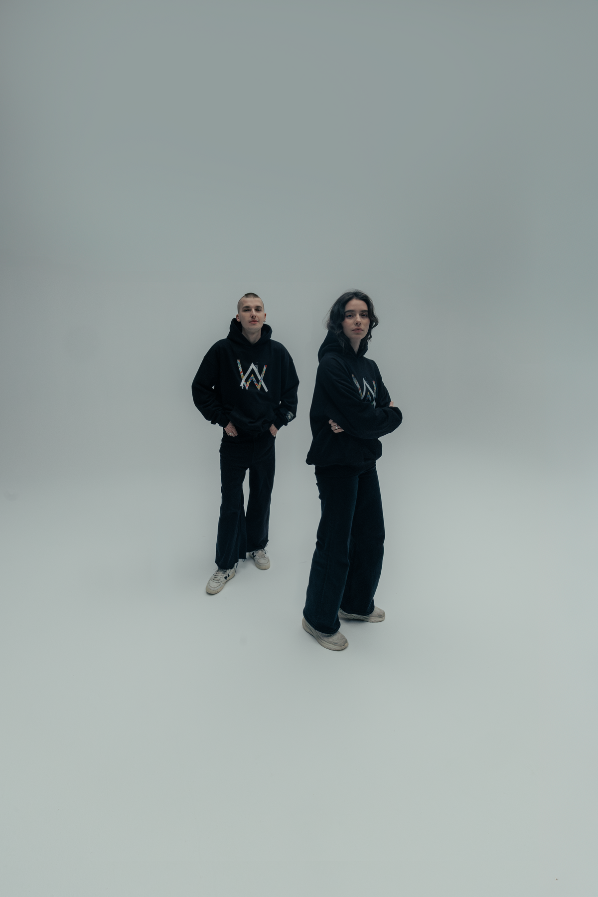 Alan Walker Tired 0 Hoodie full-length studio shot on two models, black Walker fan apparel with wide trousers