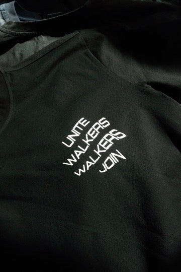 Alan Walker Unite Walkers T-shirt worn close-up, angled shot of the white Unite Walkers Join lettering