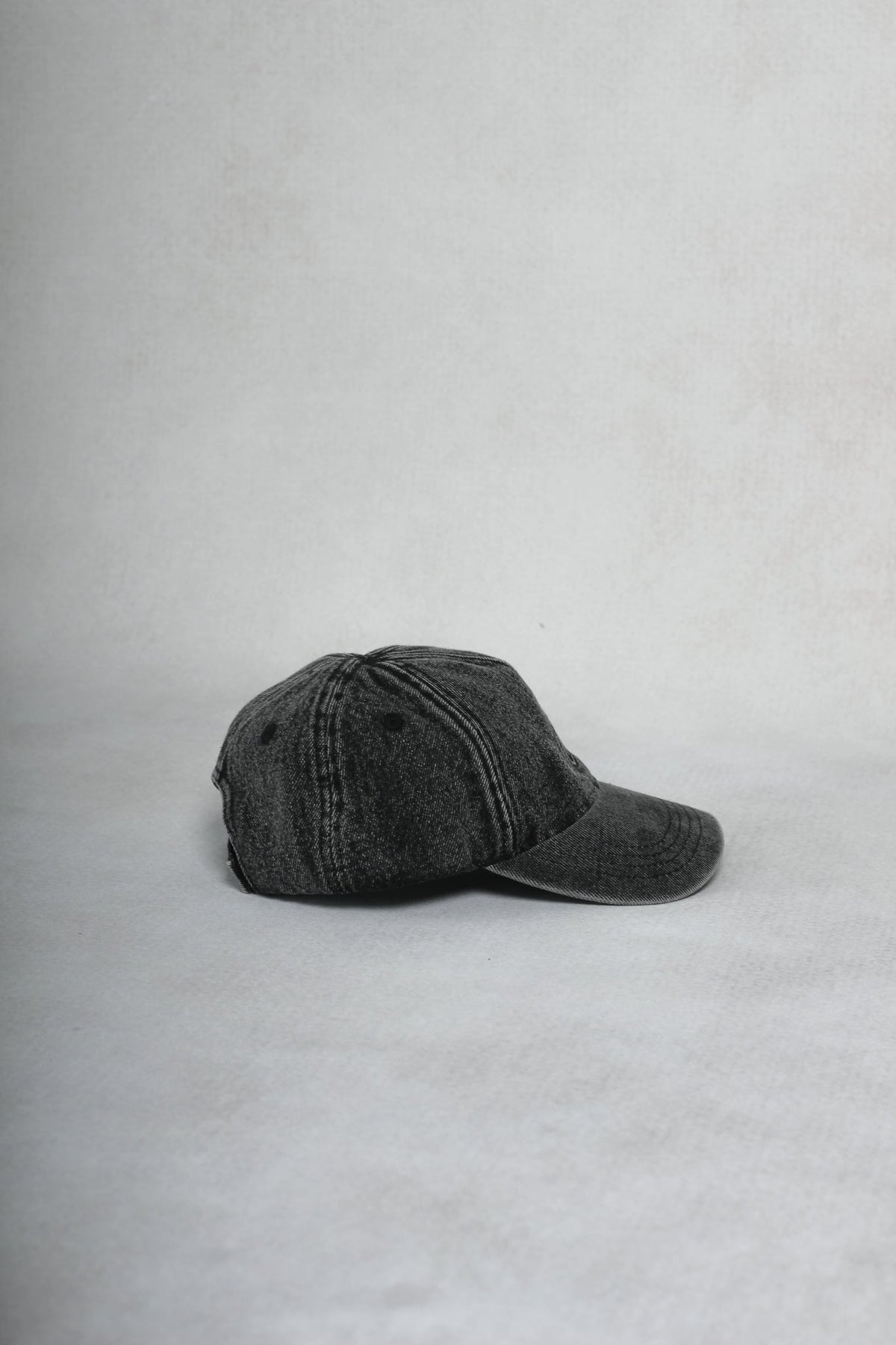 Alan Walker Washed Logo Cap side profile, faded black six-panel cap with curved brim