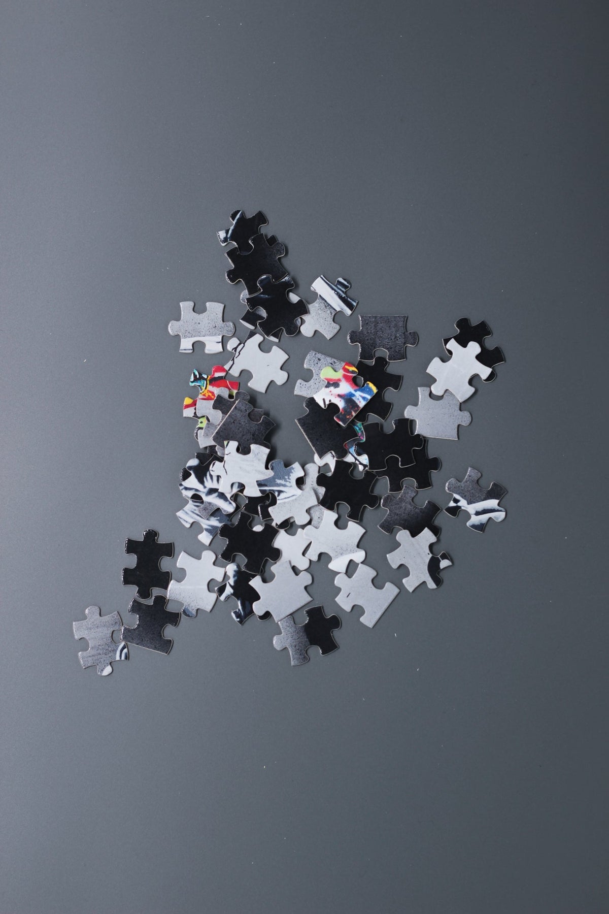 Alan Walker Heading Home Puzzle pieces scattered on a grey surface, showing the printed artwork fragments