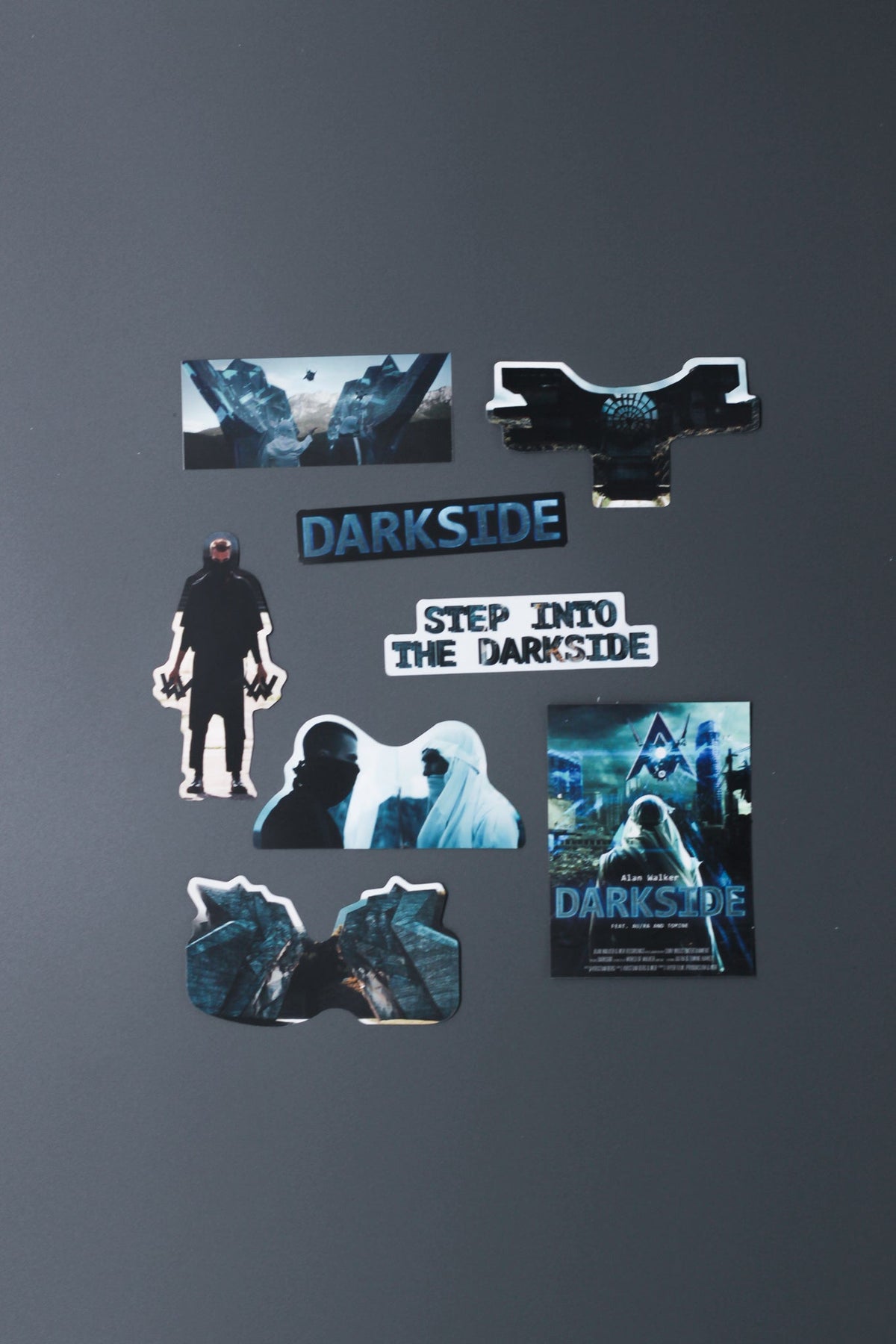 Alan Walker Darkside Sticker Pack spread out, Darkside logo, hooded figure and scene decals on a grey surface