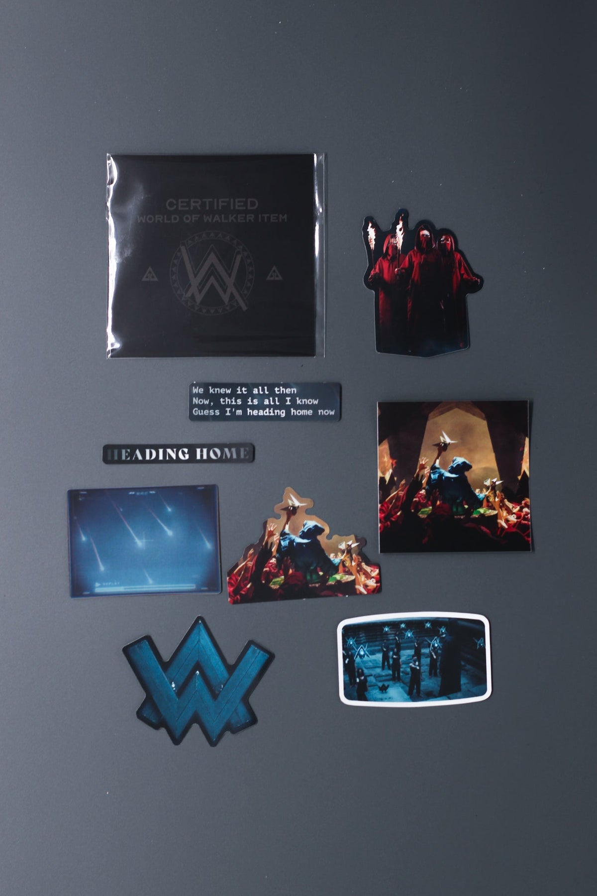 Alan Walker Heading Home Sticker Pack laid out, film scene, logo and lyric decals beside the branded sleeve
