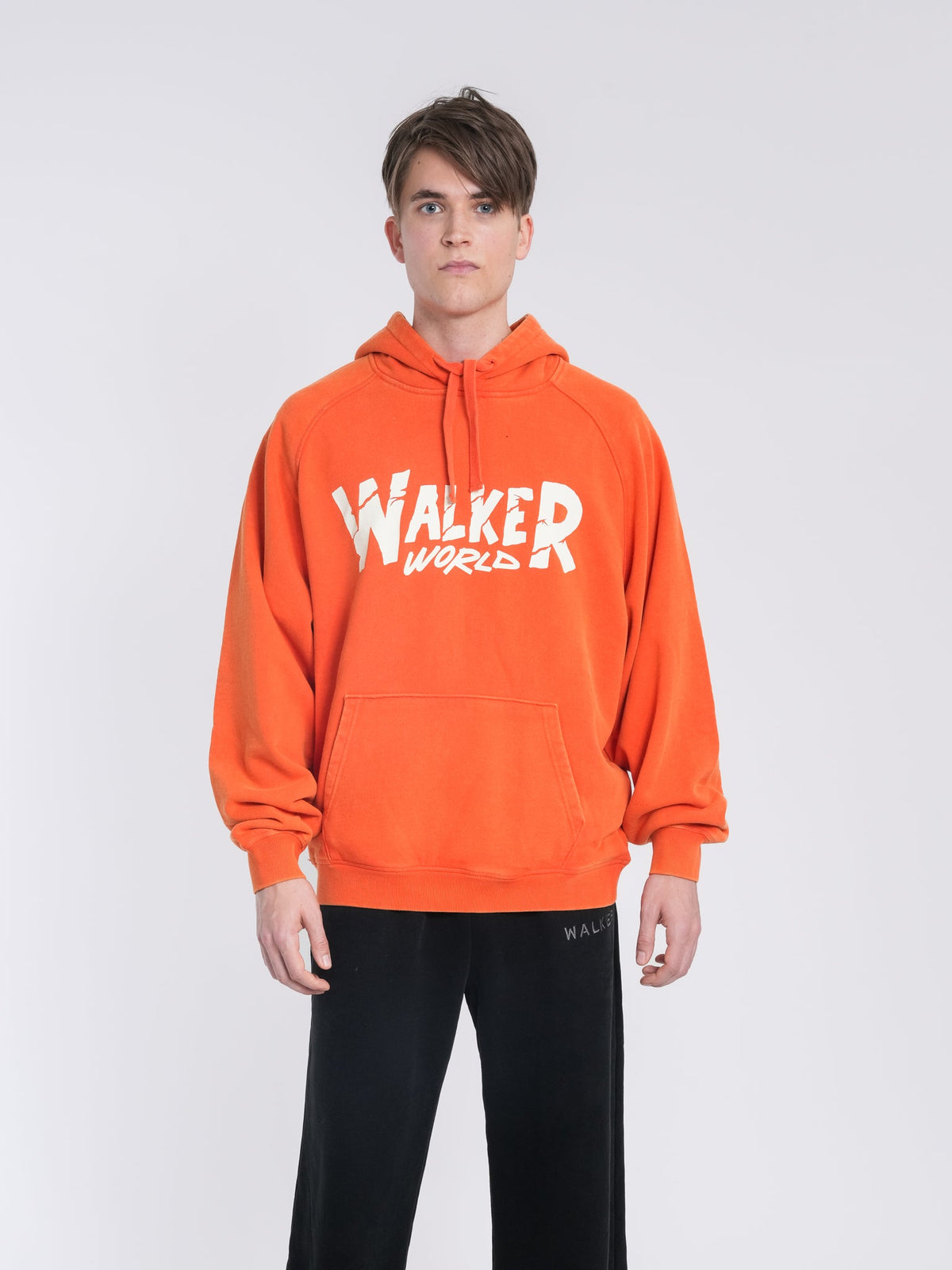 Alan Walker Walkerworld Logo Hoodie worn by a model in orange with the white Walkerworld logo across the chest