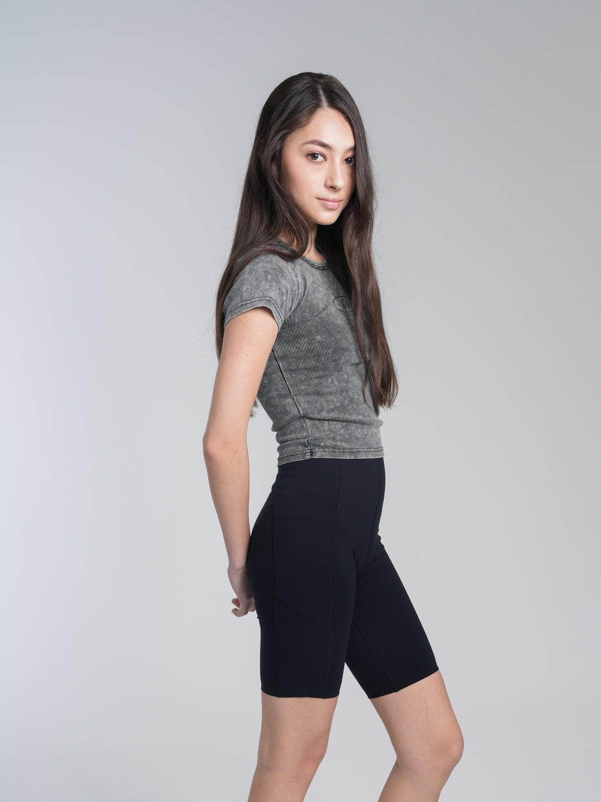 Alan Walker Washed Fitted Tee side view on a model, cropped grey tee styled with black cycling shorts