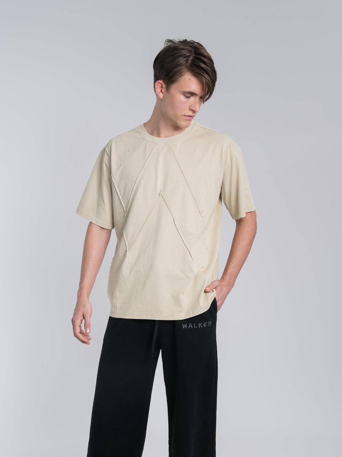 Alan Walker Stitch Logo Tee in sand beige worn by a model, oversized tee with tonal stitched AW seam detail