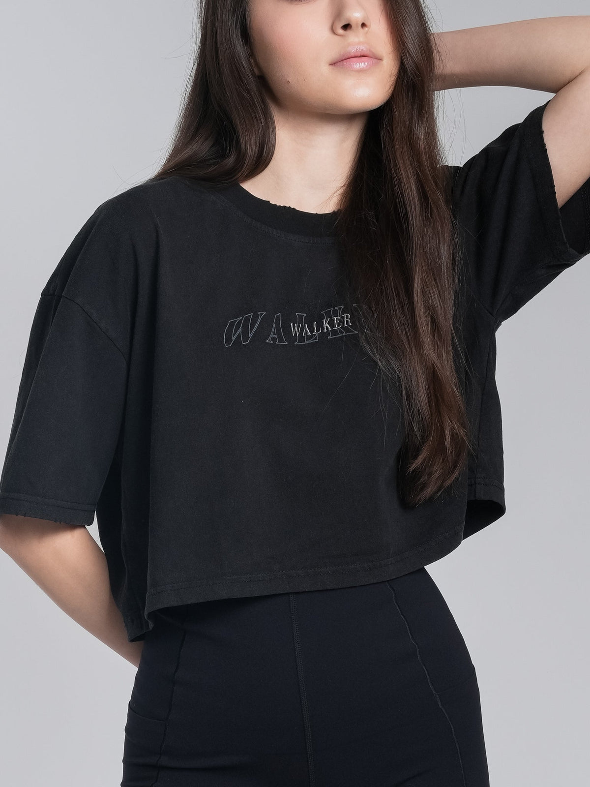 Alan Walker Cropped Tee chest close-up, subtle tonal AW logo and Walker wordmark on washed black cotton