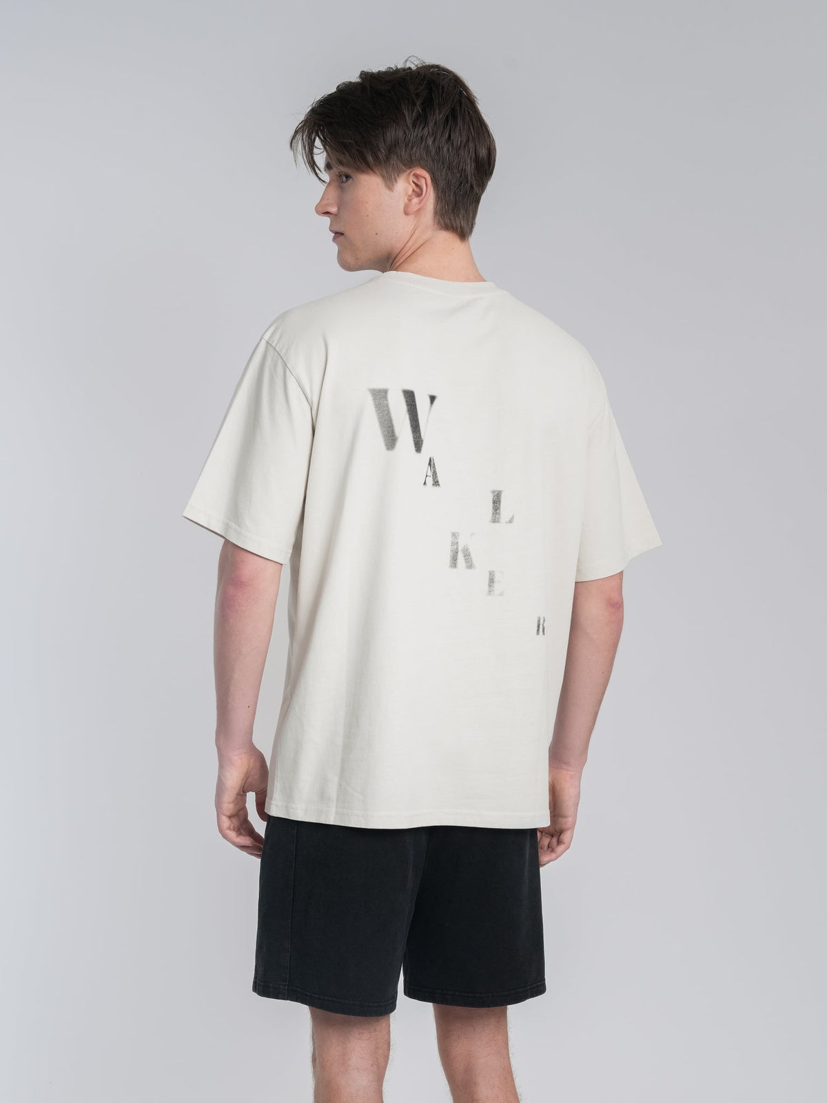 Alan Walker Off-White Walker Tee back view on a model, tonal stacked WALKER lettering on cream cotton