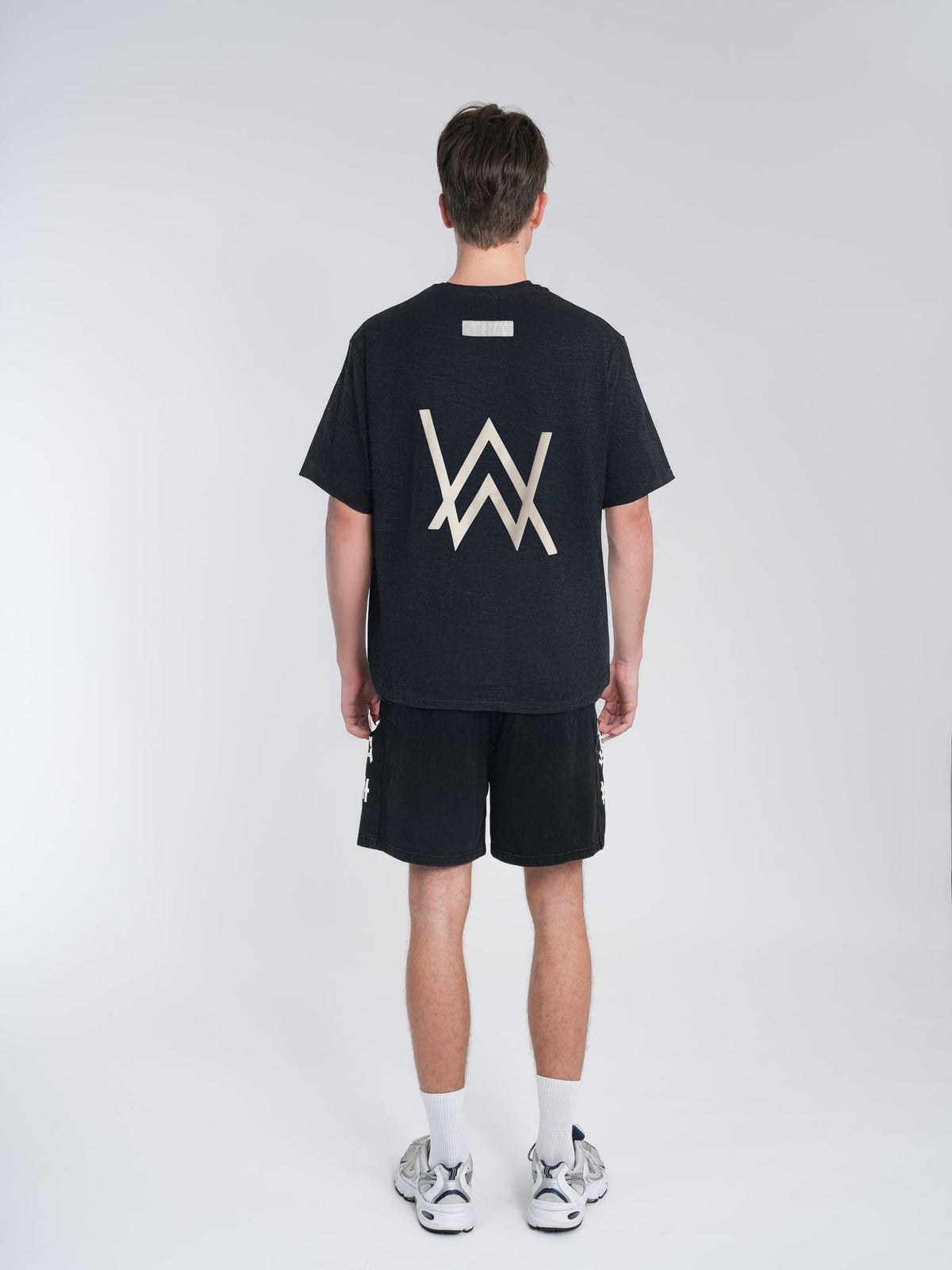 Alan Walker World of Walker Core Tee back view on a model, oversized black tee with large white AW logo