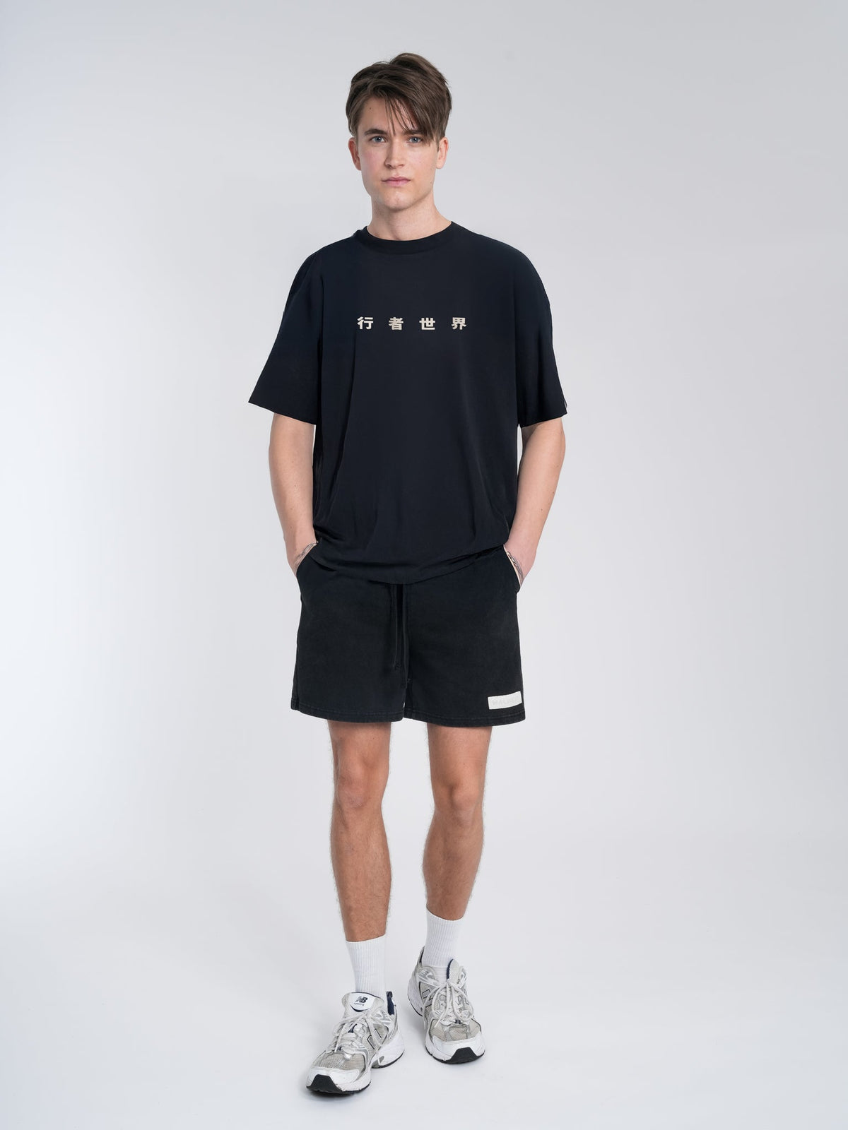 Alan Walker World of Walker Core Tee front on a model, black tee with small white glyph print at the chest
