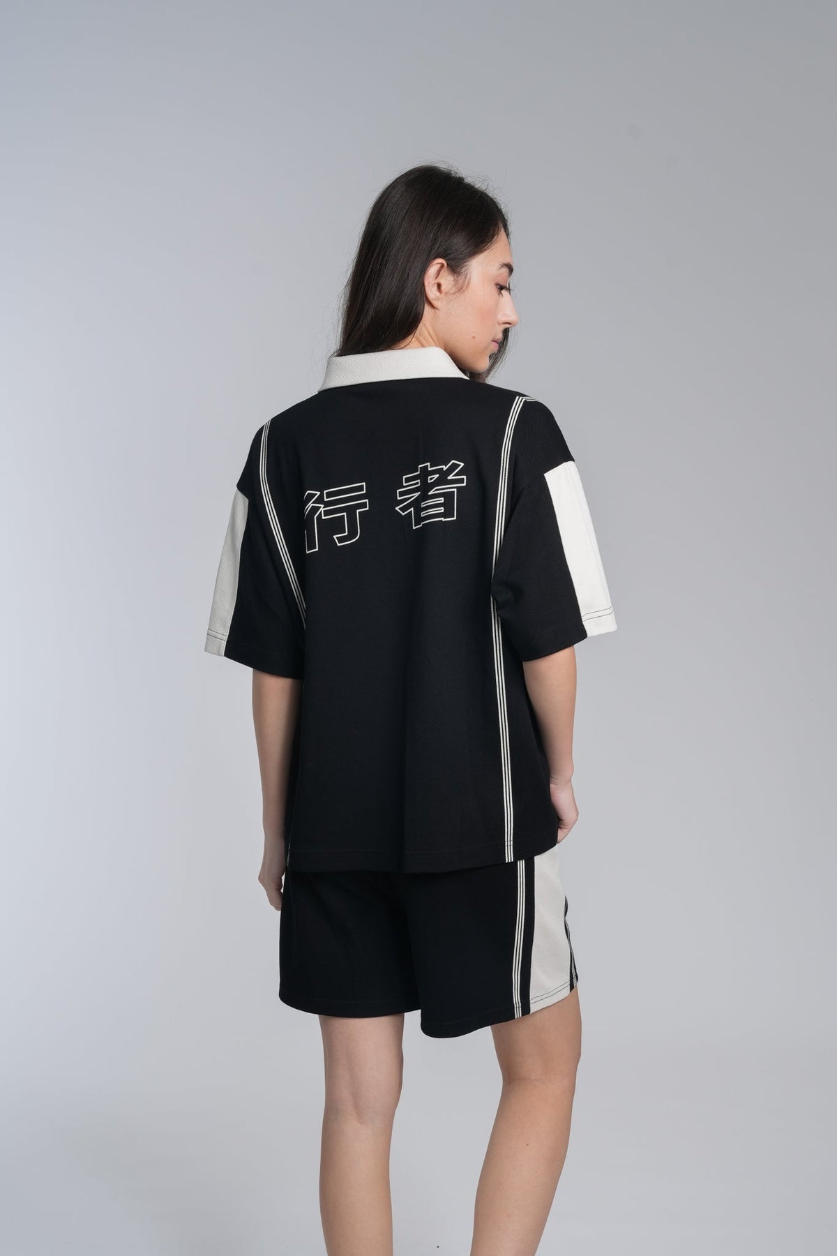 Alan Walker Polo Shorts back view on a model, black pair styled with the matching striped polo top