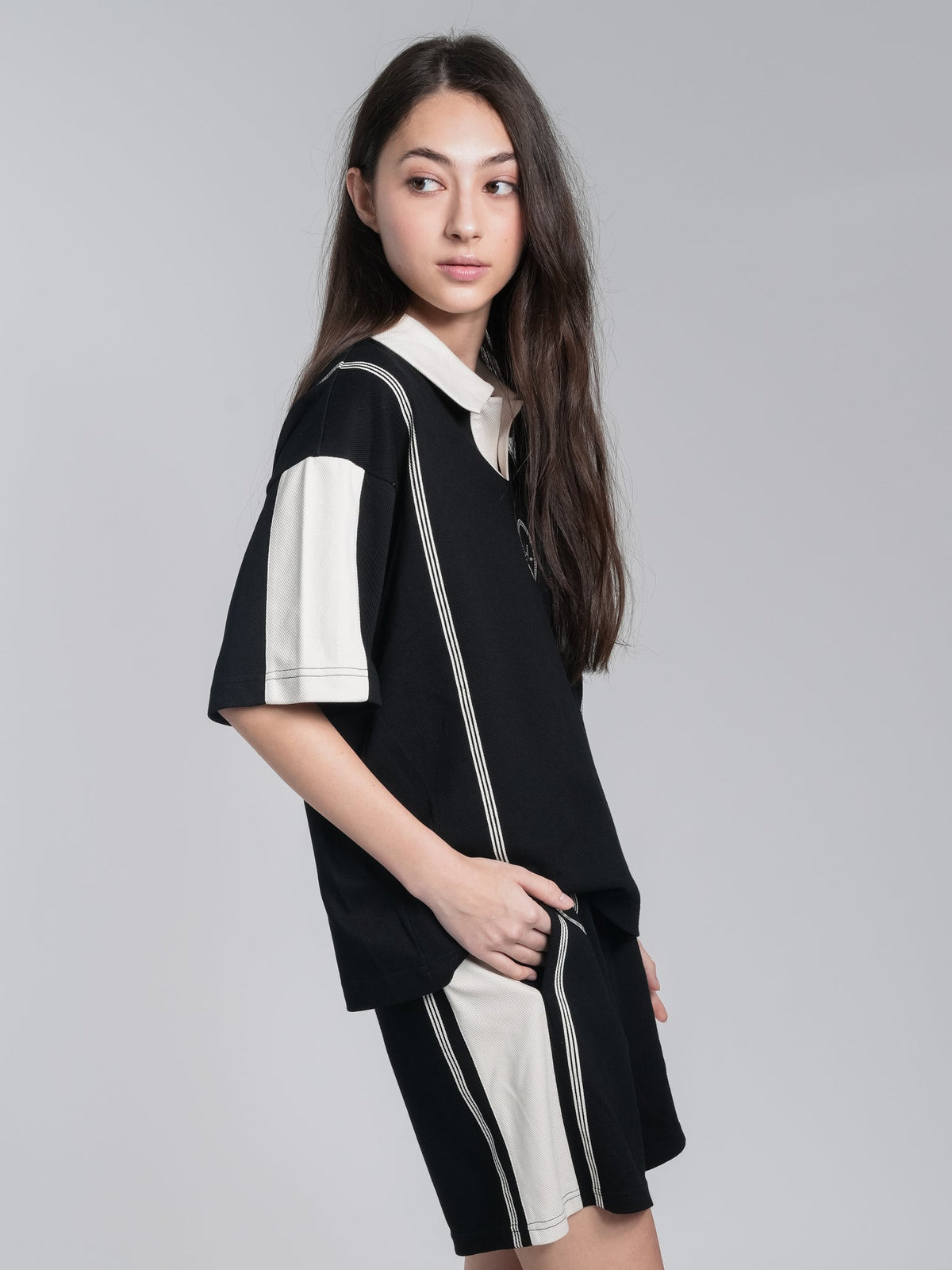 Alan Walker Polo Shorts side view on a model, cream stripe running down the black relaxed-fit leg