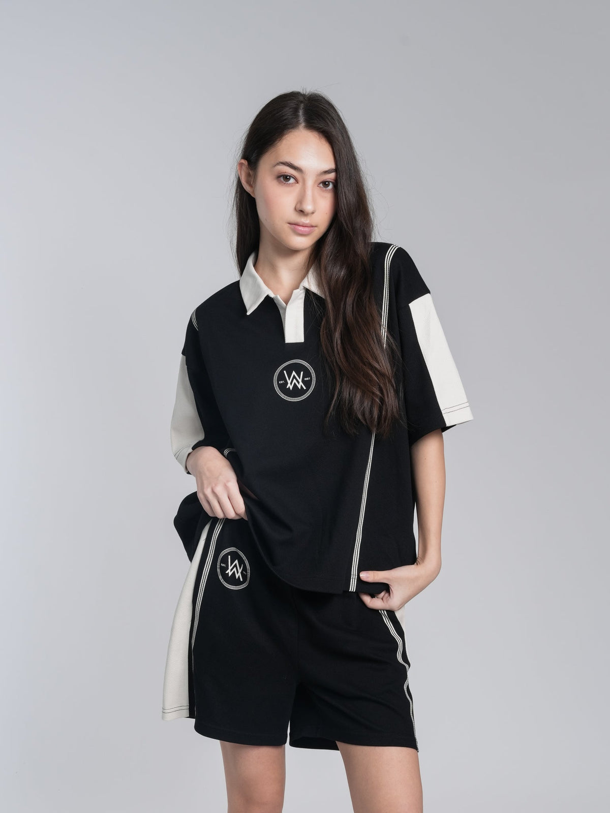 Alan Walker Polo Shorts front on a model, black shorts with cream trim worn with the AW polo top