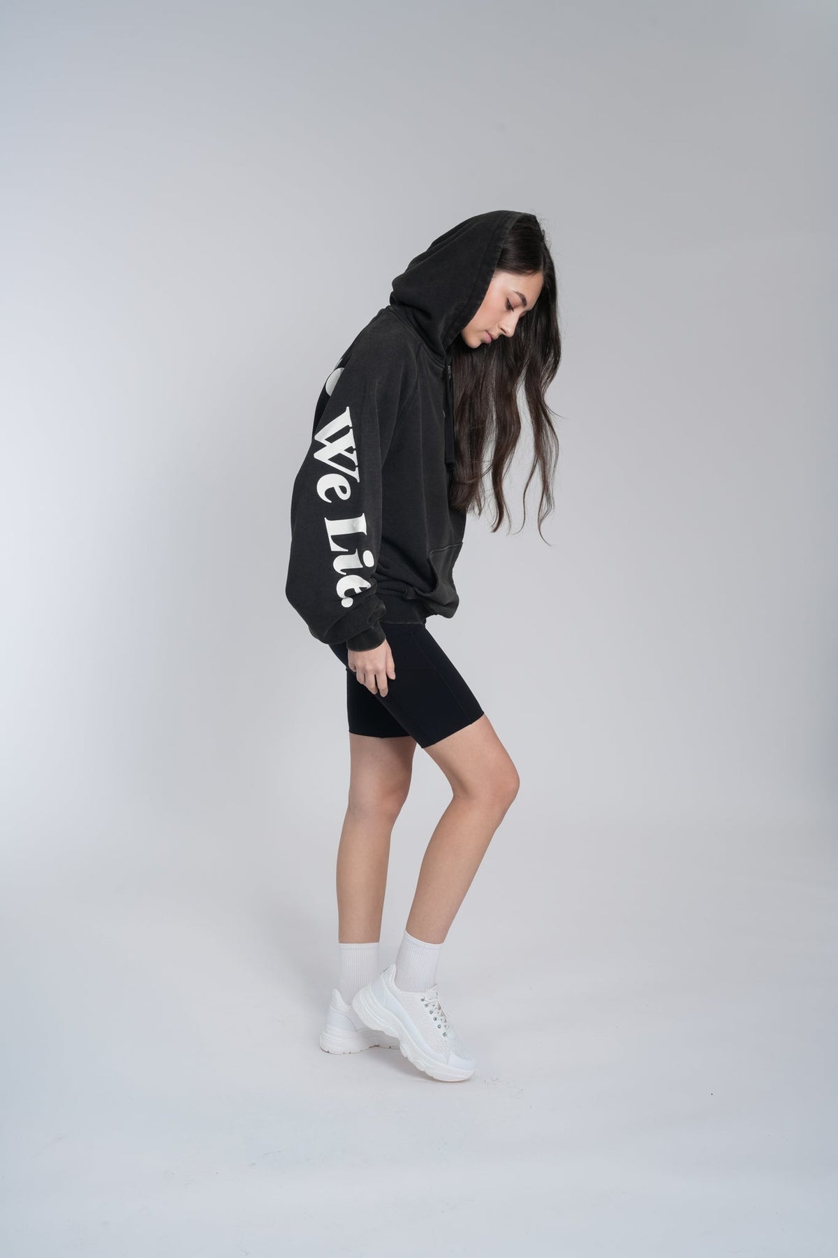 Alan Walker Lyrics Hoodie side profile on a model, We Lie script visible on the sleeve of the black hoodie