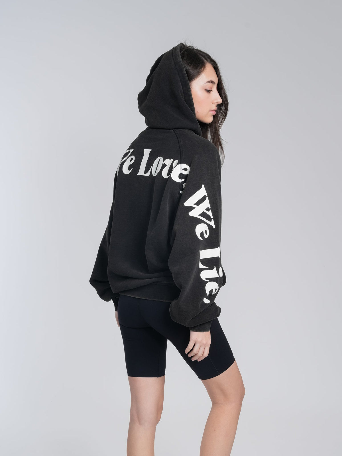 Alan Walker Lyrics Hoodie worn by a model turning away, white We Love We Lie script running down the sleeve