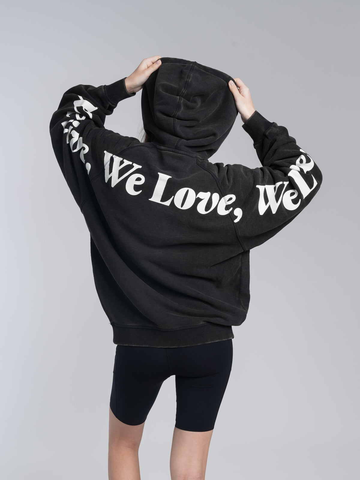 Alan Walker Lyrics Hoodie back view on a model with the hood up and arms raised, sleeve lyric print in white