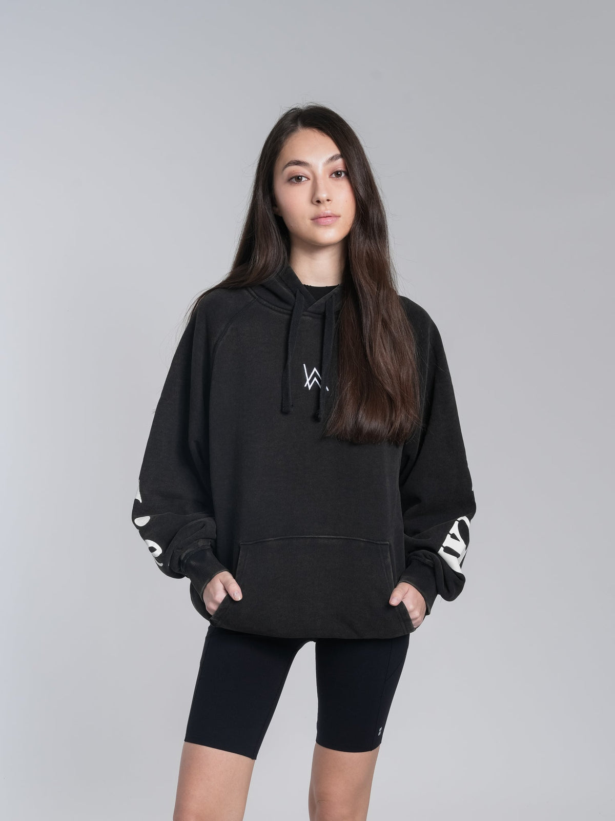 Alan Walker Lyrics Hoodie front on a model, oversized black pullover with AW chest logo and lyric sleeves