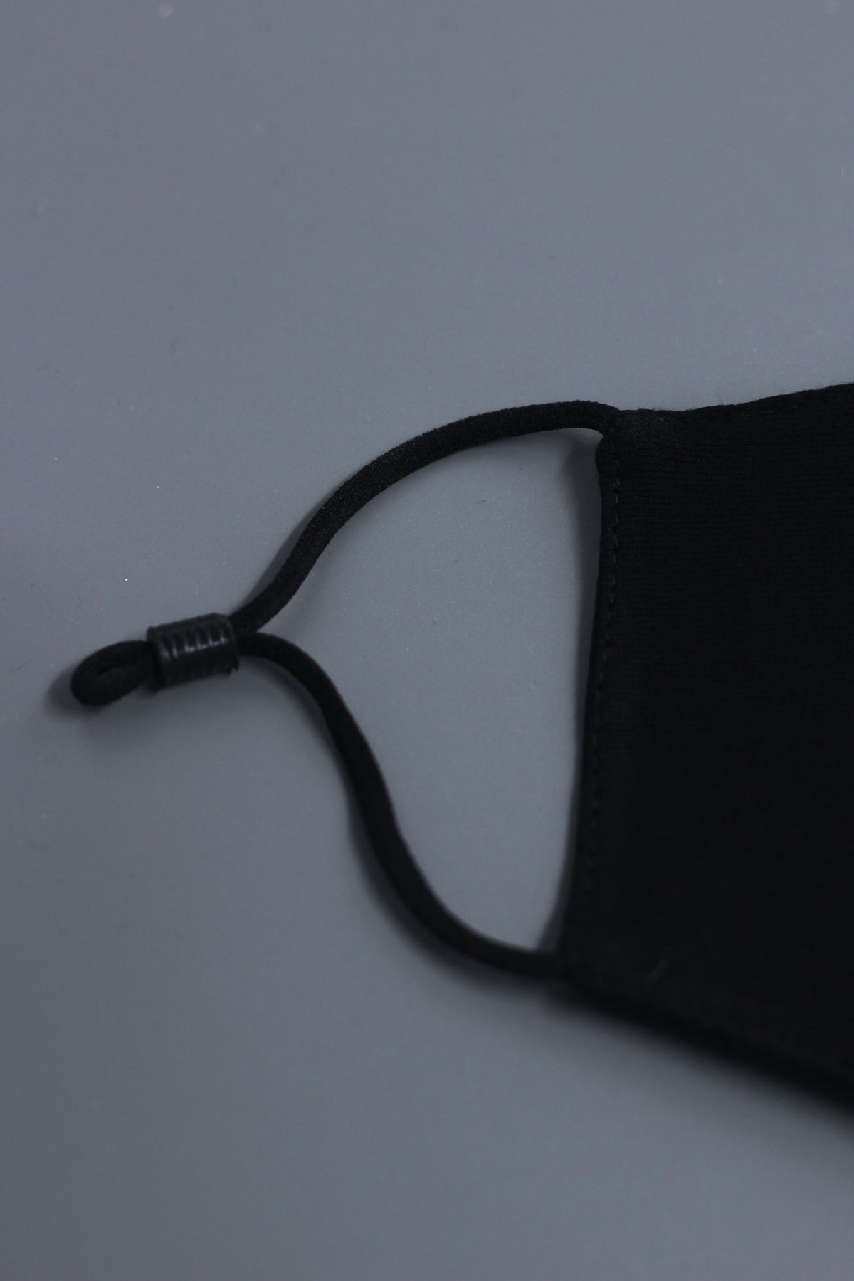 Alan Walker Tired Mask side detail, black fabric with elastic ear loop and sliding toggle adjuster