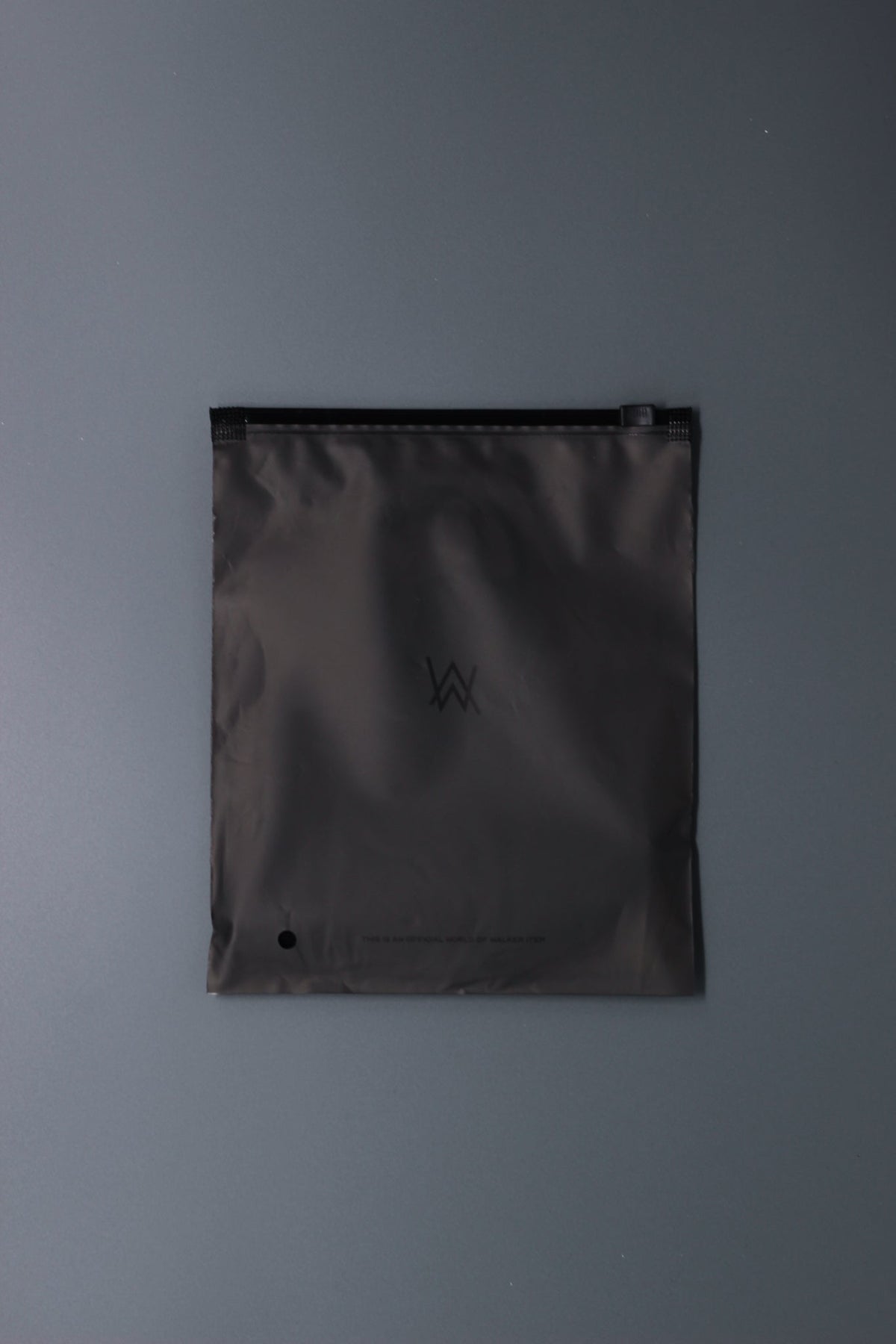 Alan Walker Tired Mask packaging, grey resealable pouch with a subtle AW logo printed on the front