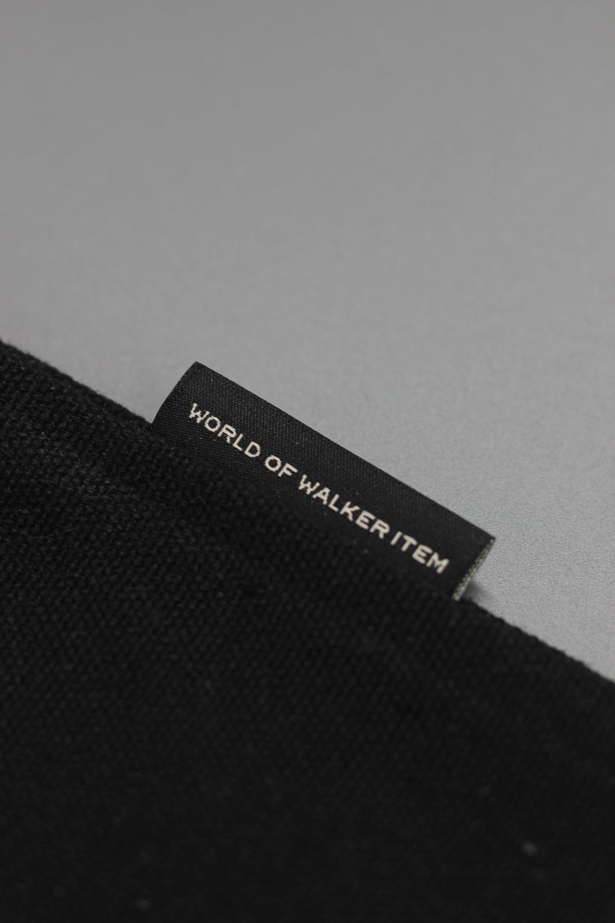Alan Walker World of Walker Monogram Pillow edge close-up with the World of Walker Item woven label