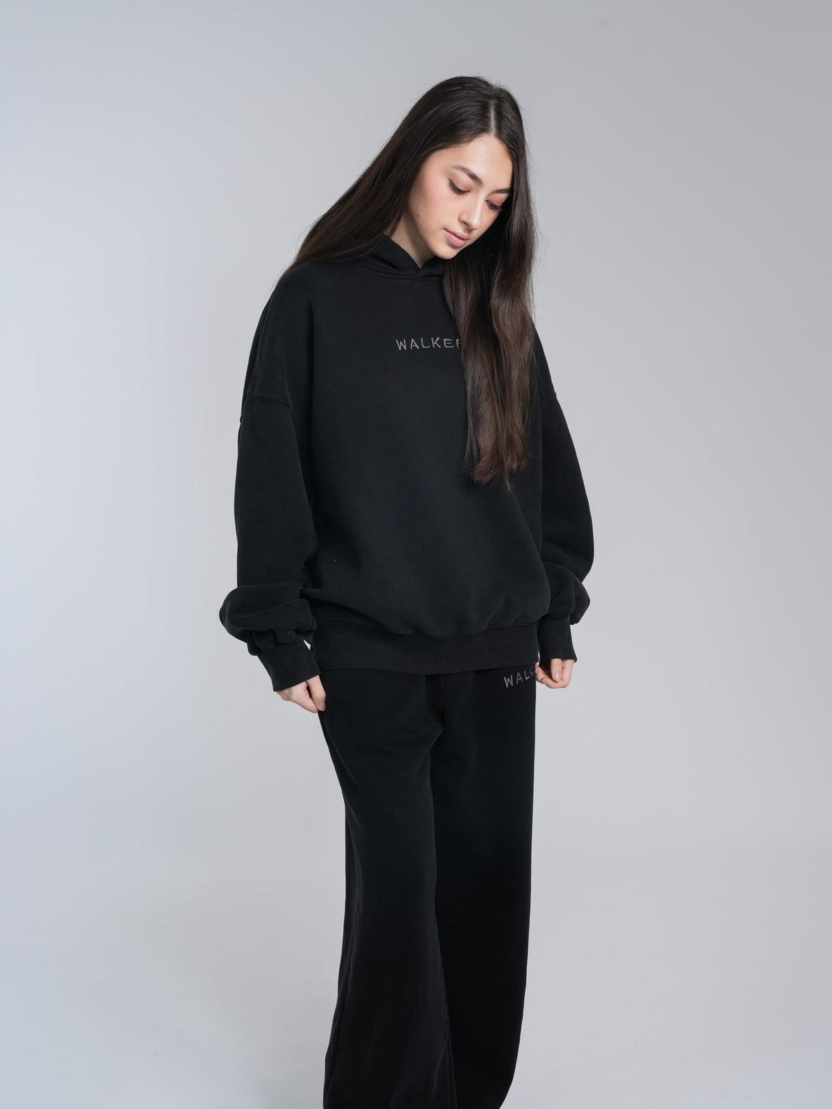 Alan Walker Core Hoodie front on a female model, black pullover with tonal Walker chest lettering