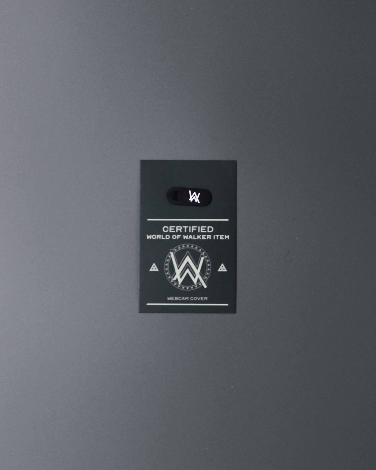 Alan Walker Webcam Cover packaging card angled view, black backer with the World of Walker crest and AW slider