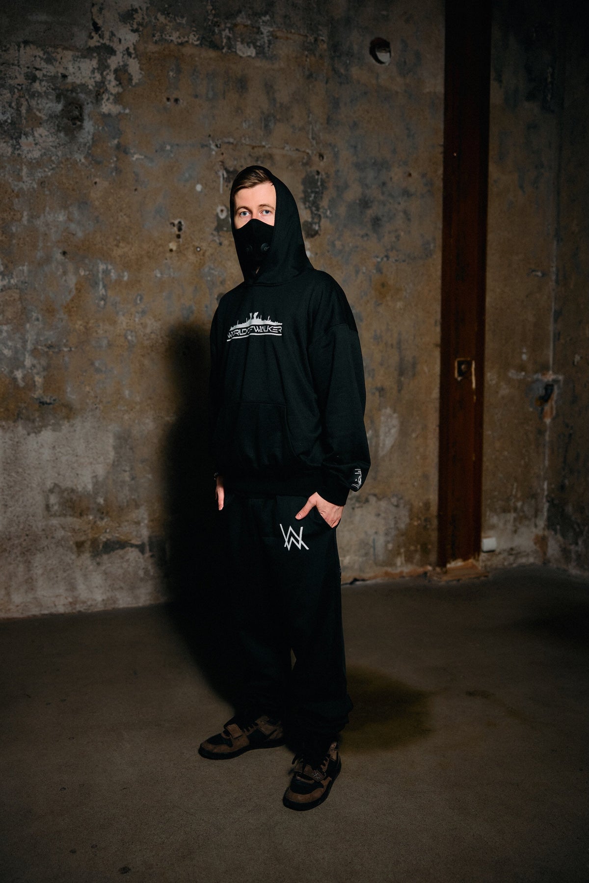 Alan Walker World of Walker Skyline Sweatpants worn with the matching black hoodie by a masked model indoors