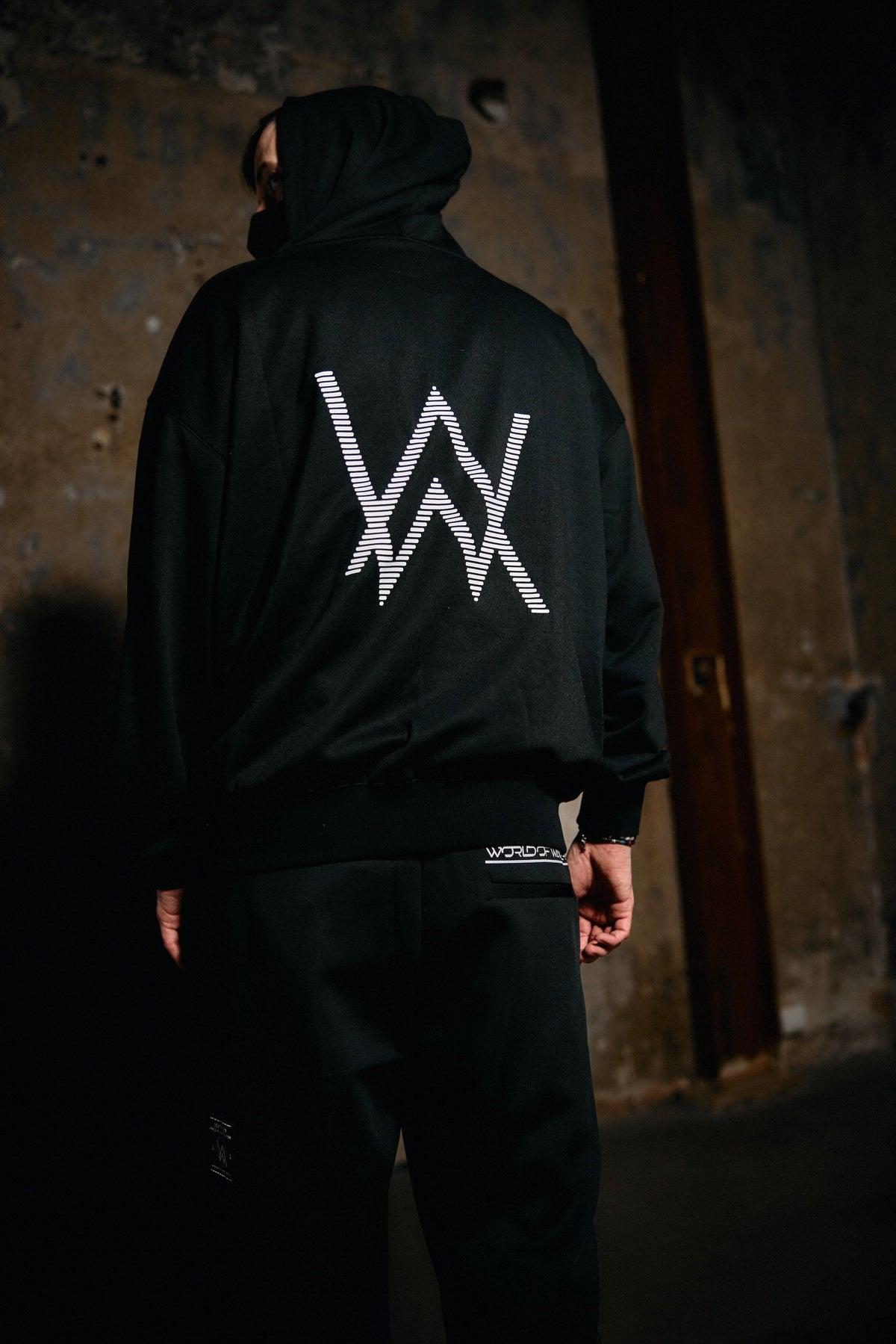 Alan Walker World of Walker Skyline Sweatpants seen from behind on a model, black joggers under the AW hoodie