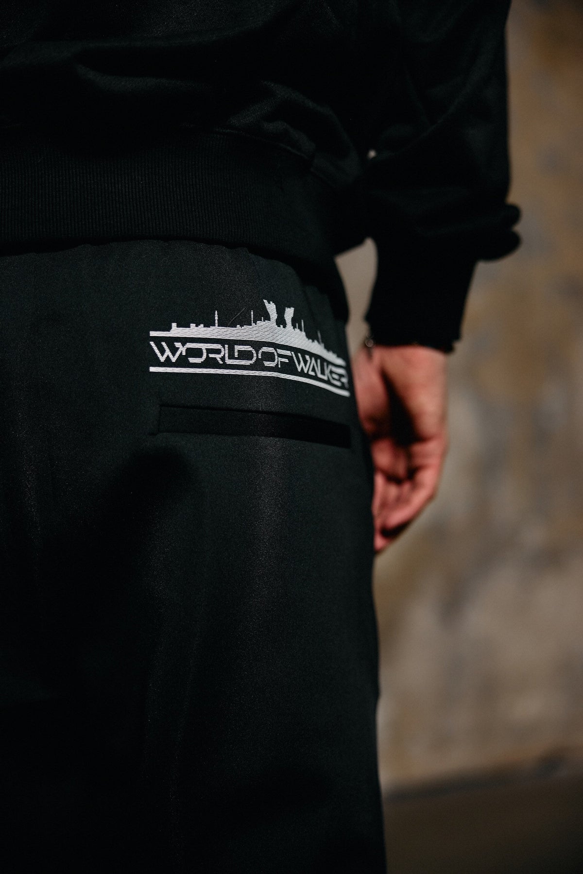 Alan Walker World of Walker Skyline Sweatpants worn by a model, close-up of the skyline logo on the back pocket