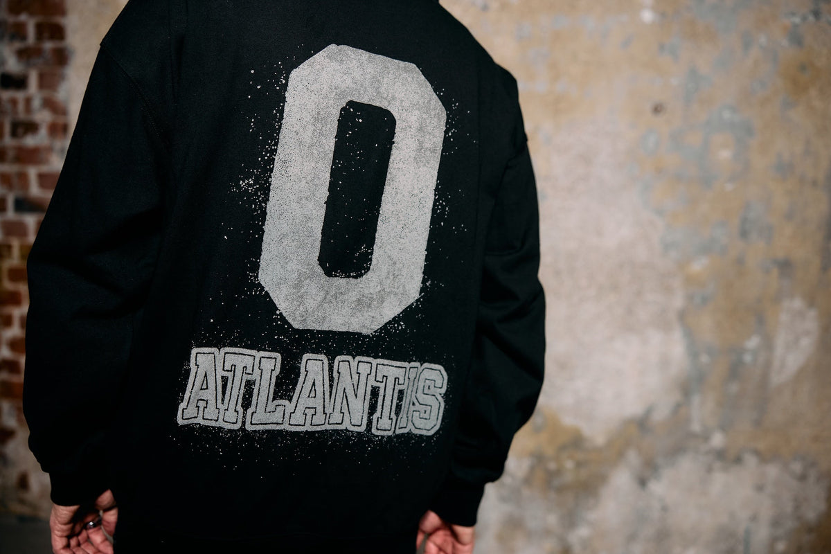 Alan Walker Atlantis 0 Hoodie worn by a model from behind against a brick wall, white 0 Atlantis back print