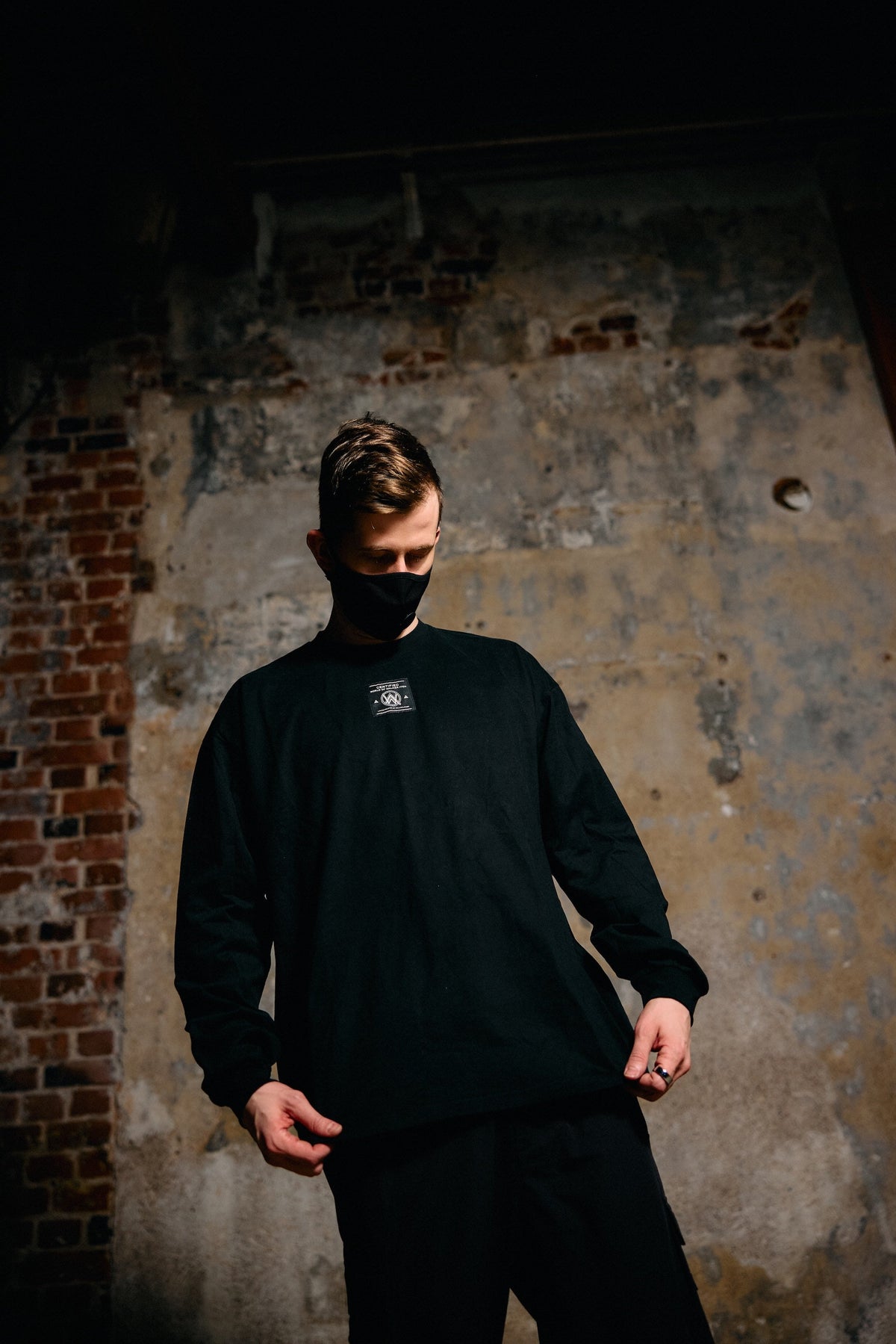 Alan Walker Prophecy Disc VIII Longsleeve worn by a masked model against a brick wall, black EDM streetwear