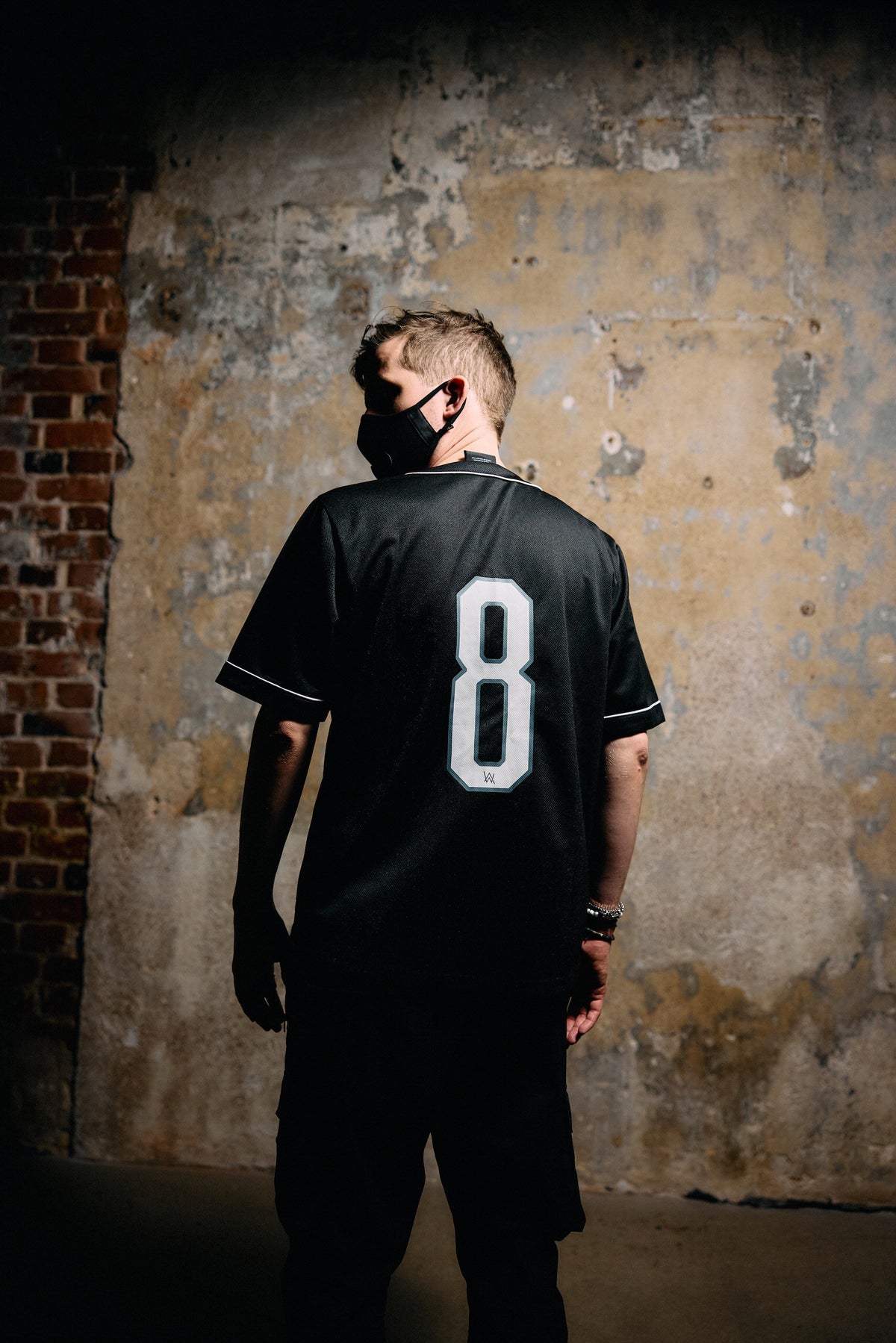 Alan Walker 8 Baseball Jersey worn from behind by a masked fan, white number 8 across the black back