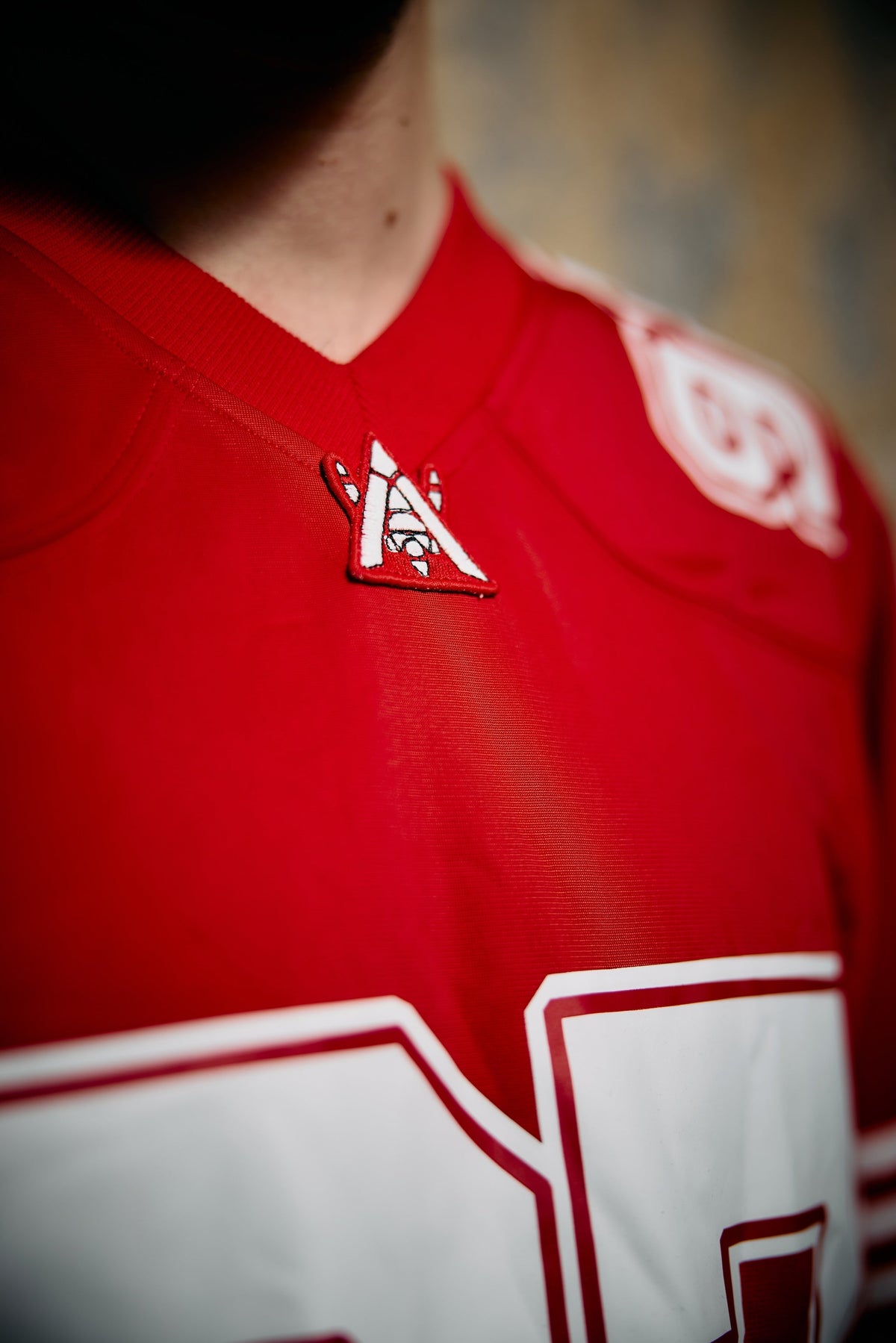 Alan Walker World of Walker 97 Jersey shoulder close-up, embroidered white AW logo on red mesh fabric