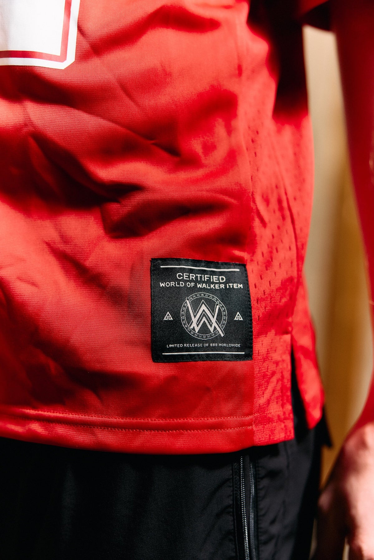 Alan Walker World of Walker 97 Jersey hem detail with the woven World of Walker label on red mesh