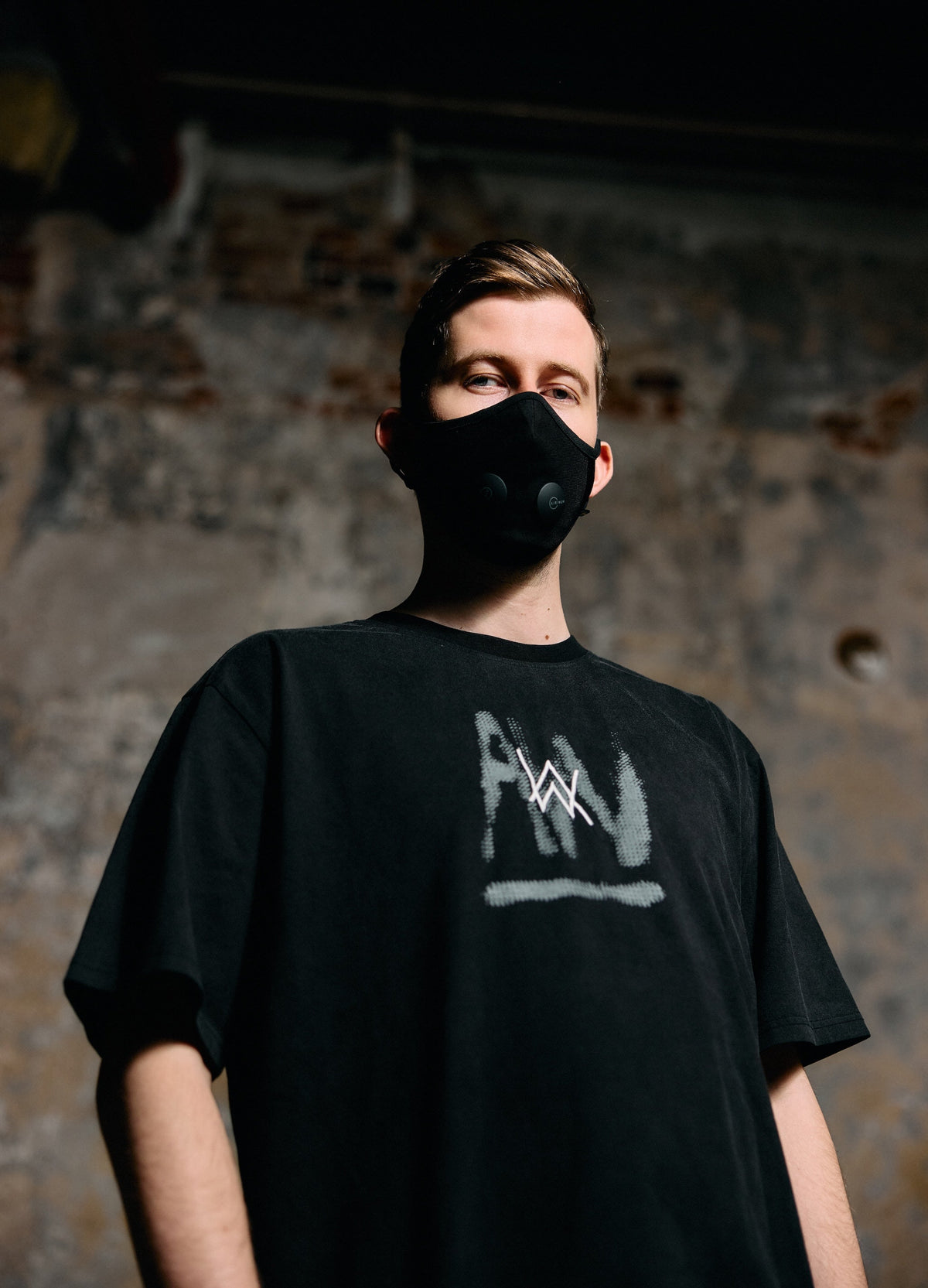 Alan Walker Faded Graffiti T-Shirt worn by a masked model against brick, grey painted AW logo on the chest