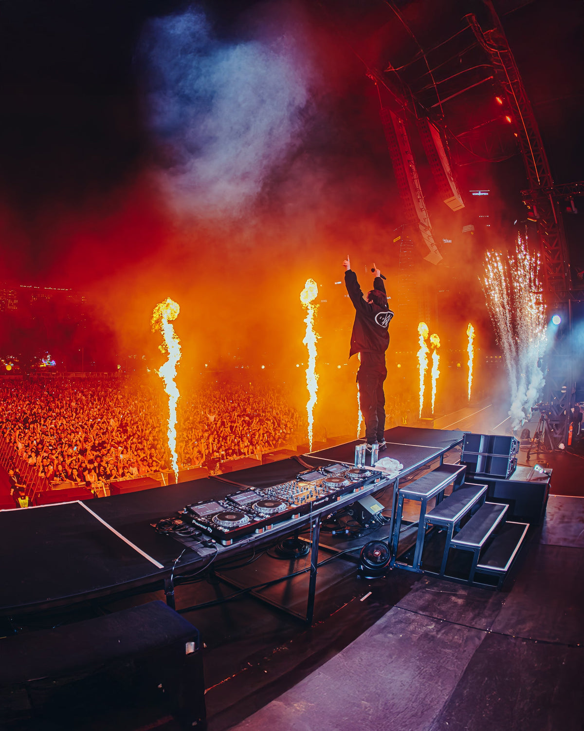Alan Walker F1 Stage Jacket worn on stage with pyro flames firing, arms raised before a packed arena crowd