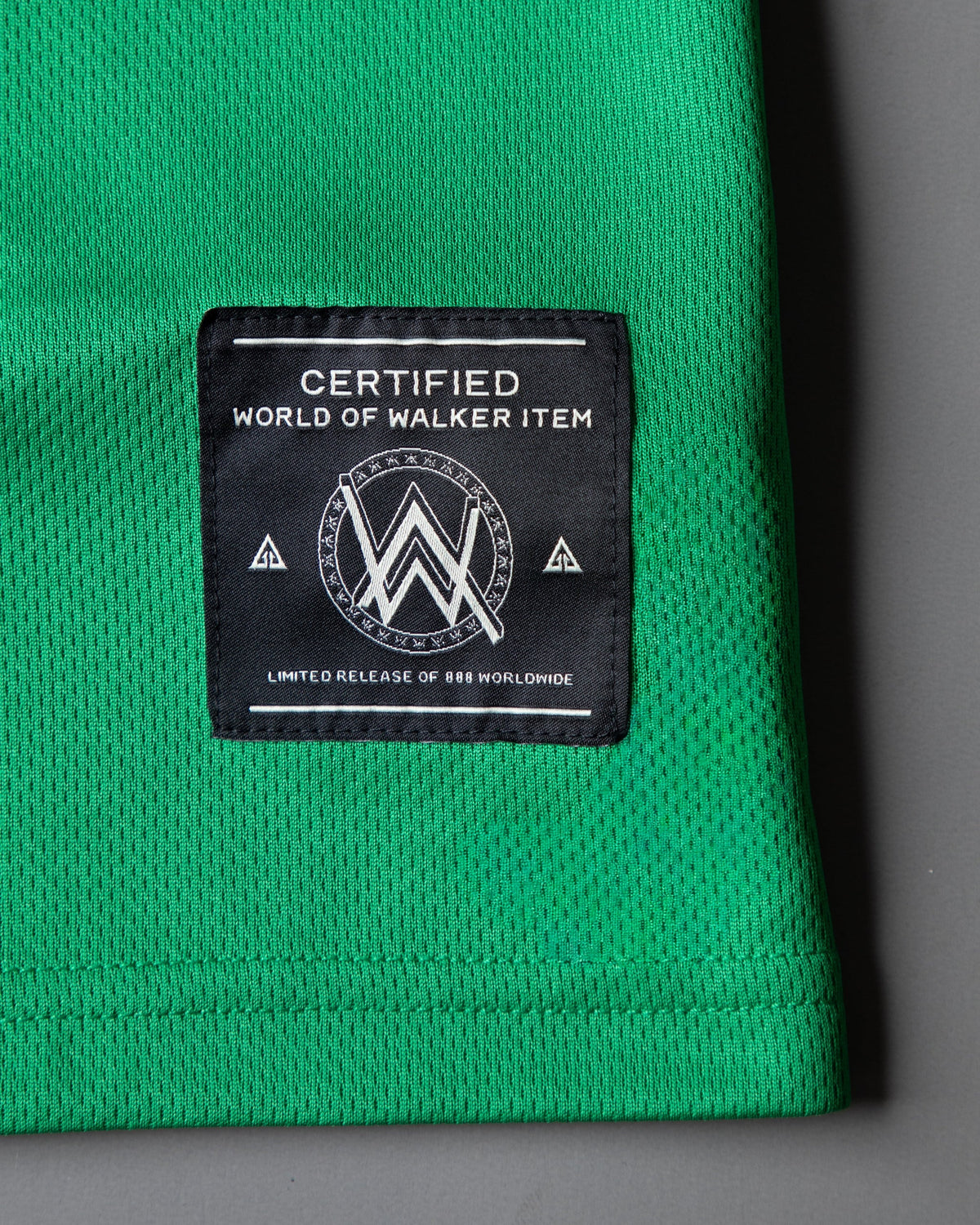 Alan Walker Creator Circle Tribe Jersey hem close-up on green mesh with the black woven World of Walker label