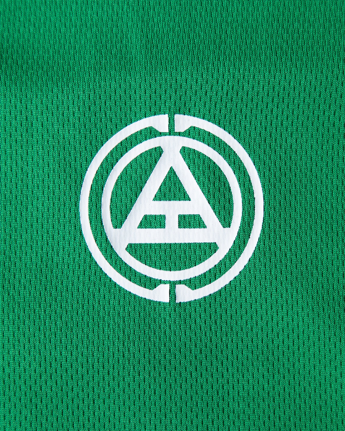 Alan Walker Creator Circle Tribe Jersey crest close-up, white circle and triangle logo printed on green mesh
