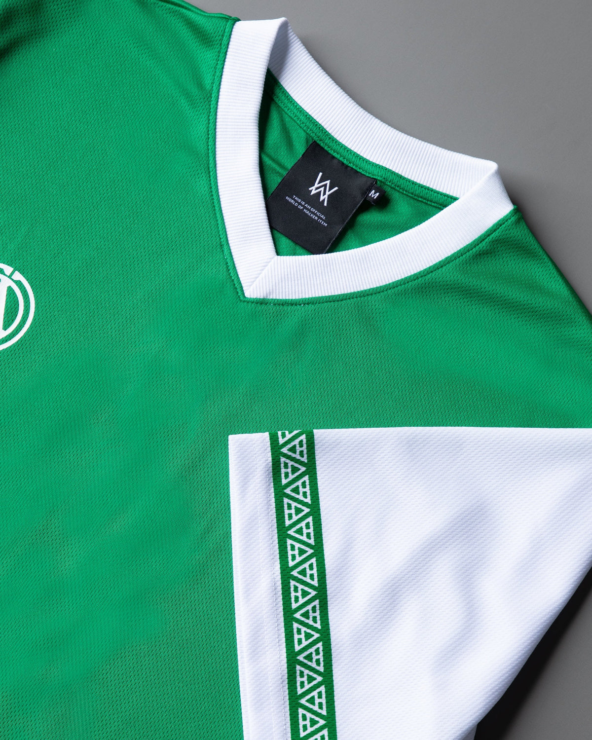 Alan Walker Creator Circle Tribe Jersey close-up of the green mesh body, white ribbed V-neck, AW size label and sleeve trim
